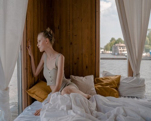 Soft light filtering through curtains into a bedroom with wooden elements creating a serene rest environment