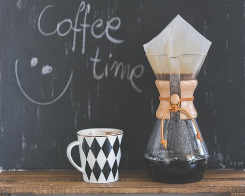 A high-quality ceramic coffee filter set over an explicit rustic wooden desk platform