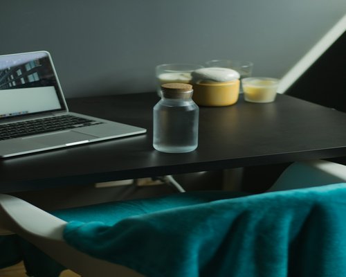 A well-lit comfortable workspace with small plants and a clean glass of mineral water on a table